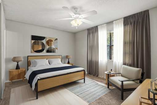 A bedroom with a bed, chair, and a ceiling fan.