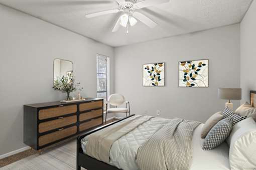 A bedroom with a bed, dresser, and two wall art pieces.