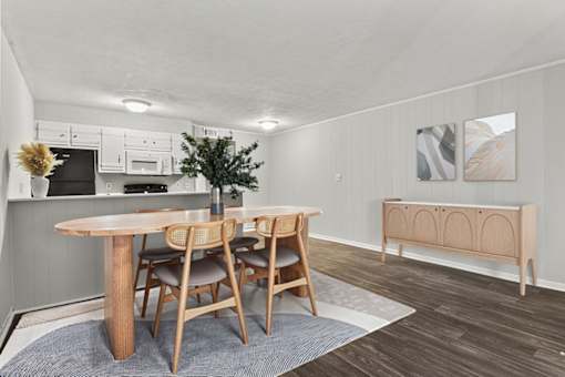 A dining room with a wooden table and chairs.