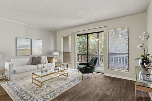 A living room with a white couch, a coffee table, and a chair.