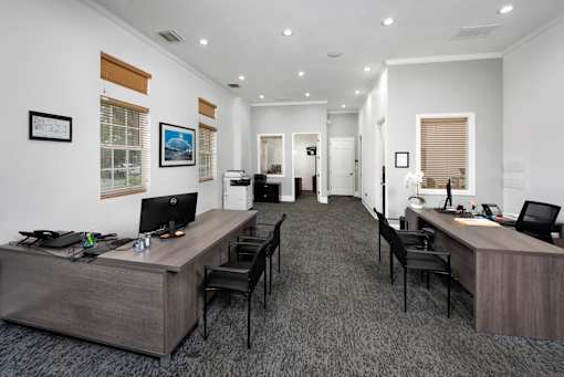 A modern office with two desks and chairs.