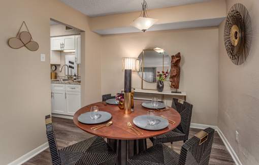 A dining room with a round table set for two.