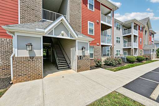 A red and white Hawks Landing apartment building in Hickory NC featuring a staircase leading to the entrance