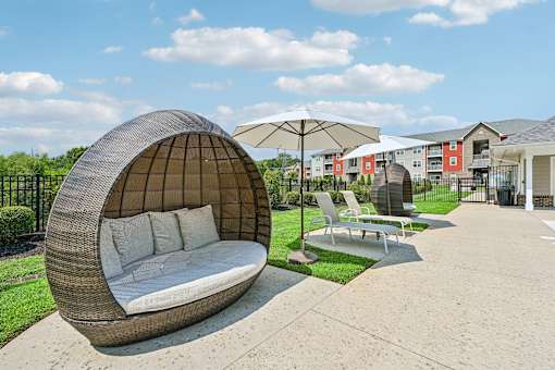 A white cushioned lounge pod at the Hawks Landing pool in Hickory NC providing a relaxing seating area for residents