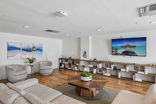 A living room with a large screen TV on the wall.