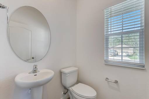 a bathroom with a toilet sink and mirror