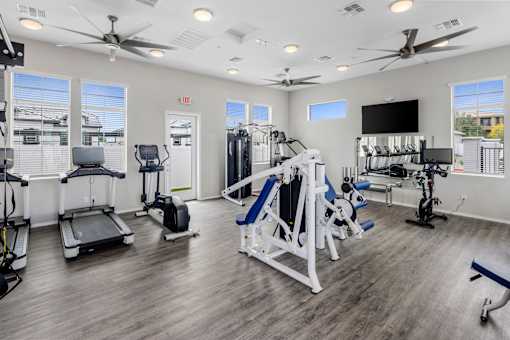 A spacious gym with a variety of equipment including treadmills, exercise bikes, and weight machines.