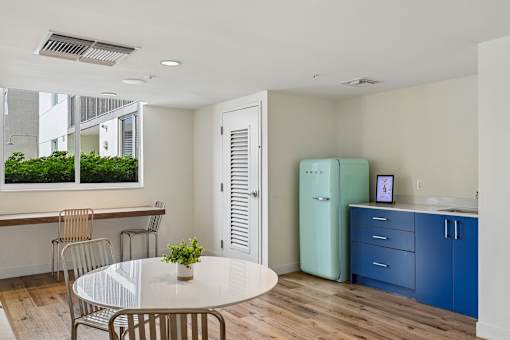 A kitchen with a table and chairs and a refrigerator.