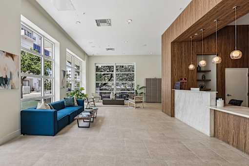 A reception area with a blue sofa and a white reception desk.