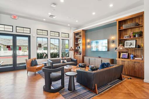 A living room with a black couch and a wooden floor.