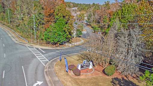 Element at 4411 Macon Apartments A road with a sign that says 4211 is surrounded by trees.
