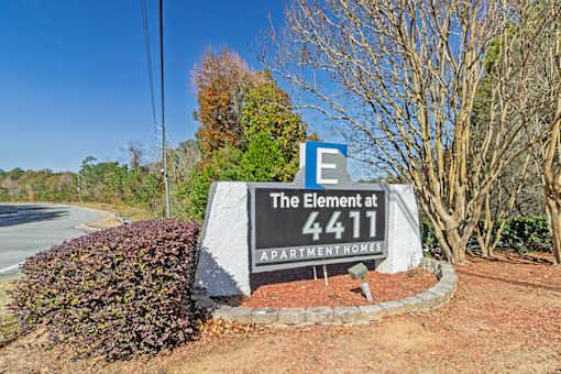 Element at 4411 Macon Apartments A sign for The Element at 4411 APARTMENT HOMES is in front of a road.