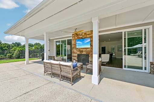 An outdoor lounge area at Hawks Landing in Hickory NC featuring a mounted TV and comfortable seating