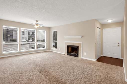 A living room with a fireplace and a ceiling fan.
