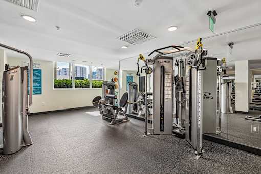 A gym with a variety of equipment including treadmills, weights, and exercise machines.