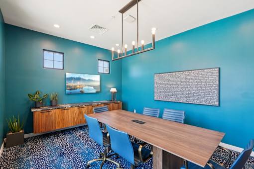 A conference room with a long table and chairs.
