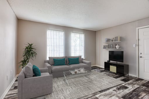 Fort Worth, TX Apartments for Rent- Monarch Pass- Living Room with Grey Furniture, Grey Rugs, and Large Windows