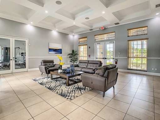 A spacious living room with a large grey sofa set and a coffee table in the center.
