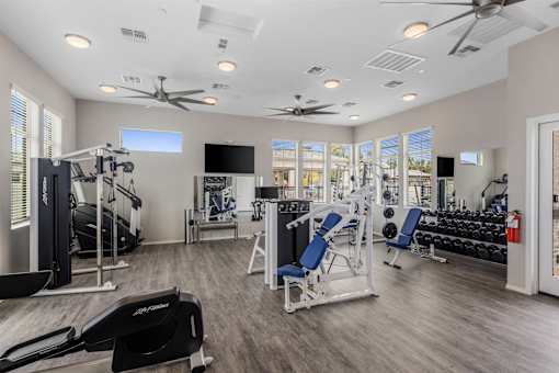 A spacious gym with a variety of equipment including treadmills, weight machines, and a bench press.