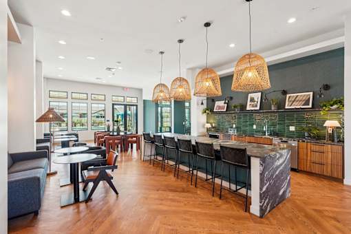 A modern living room with a kitchen area in the background.