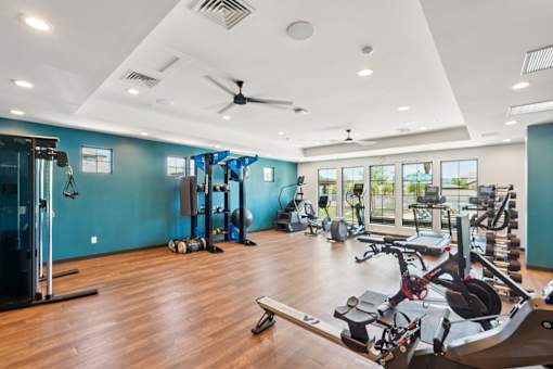 A gym with a variety of equipment including treadmills, weights, and exercise machines.