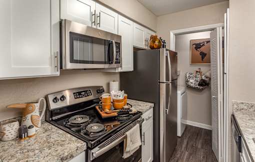 A kitchen with a black refrigerator and stove.