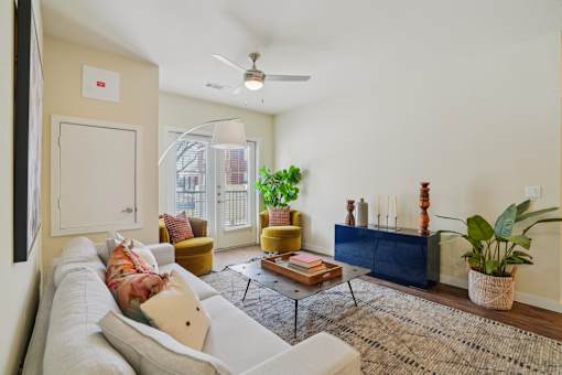 A living room with a white couch and a rug.
