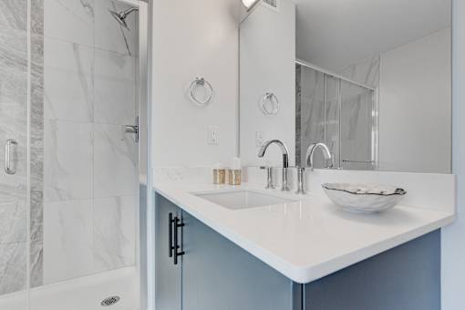 A white sink with a bowl of glasses on it.
