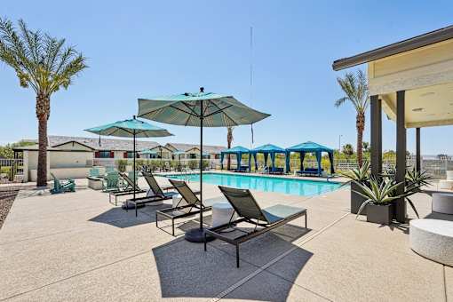 A poolside area with lounge chairs and umbrellas.