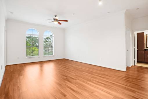 A room with wooden floors and a ceiling fan.