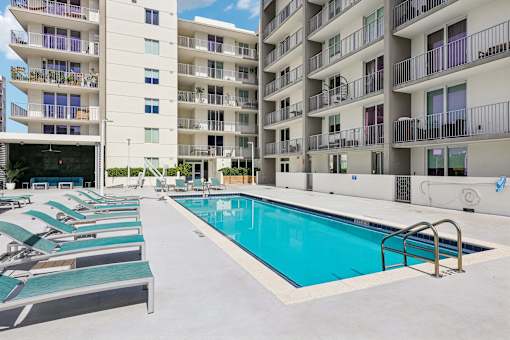 A swimming pool in front of apartment buildings.