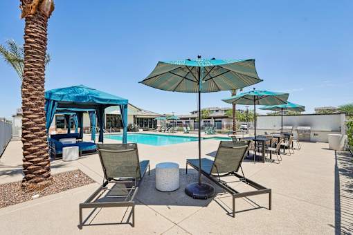 A pool area with lounge chairs and umbrellas.