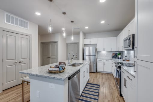 a large kitchen with white cabinets and stainless steel appliances