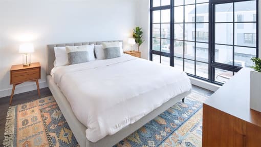 Light filled bedroom with floor to ceiling windows and modern furnishings
