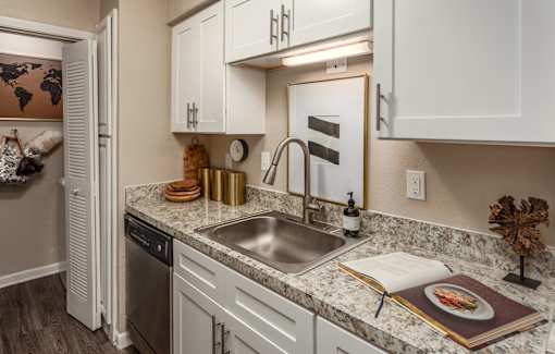 A kitchen with a sink and a book on the counter.