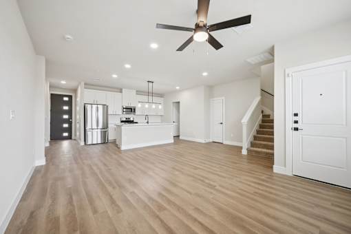 A spacious room with a ceiling fan and wooden flooring.