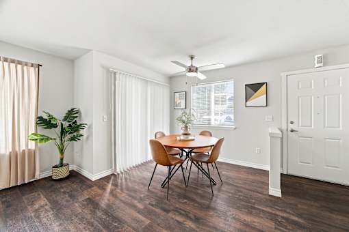 A room with a table and chairs and a plant.