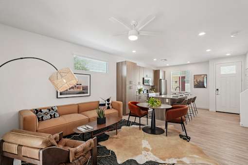 A living room with a brown couch and a cowhide rug.