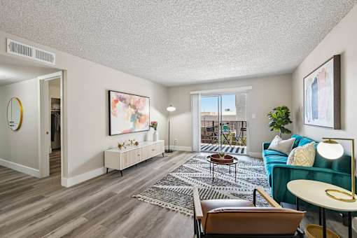 A living room with a blue couch and a rug.