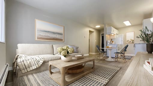A living room with a couch, coffee table, and a painting of a beach scene on the wall.