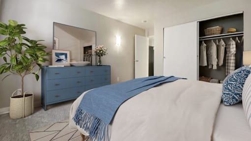 A bedroom with a bed, dresser, and mirror.