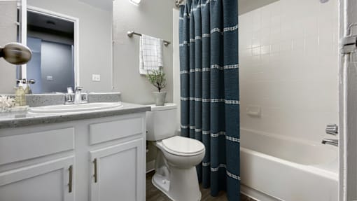 A bathroom with a white toilet, sink, and bathtub.
