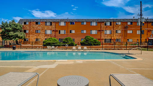 A large swimming pool in front of a brick building.
