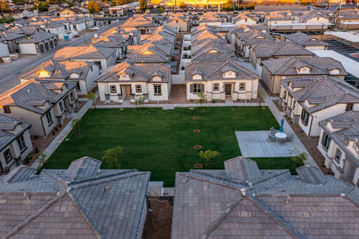 Pet-Friendly Apartments in Phoenix AZ - The Crofton at Sheely Farms - Aerial View of the Property and Community, with a Grassy Lawn in the Middle