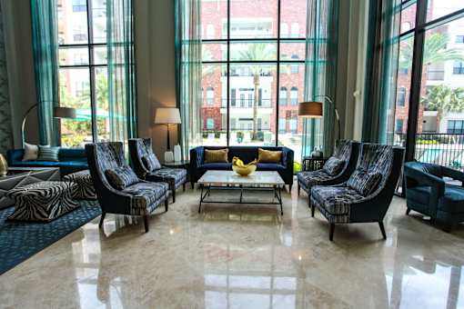 A living room with a large window and a view of a building.