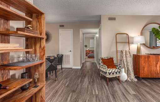 A living room with a wooden shelf and a chair.