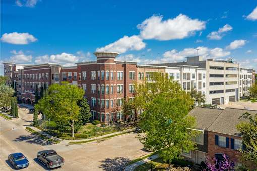 A sunny day in a town with a mix of modern and older buildings.