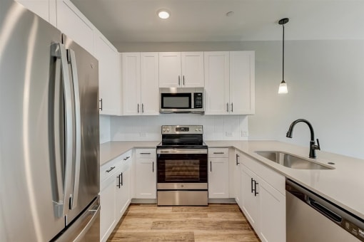  Houses For Rent In Denton, TX - Carmel Villas - Kitchen With Modern Features, Soft Close White Cabinets and Drawers, Wood Vinyl Plank Flooring, Stainless Steel and Energy-Efficient Appliances, And Qu