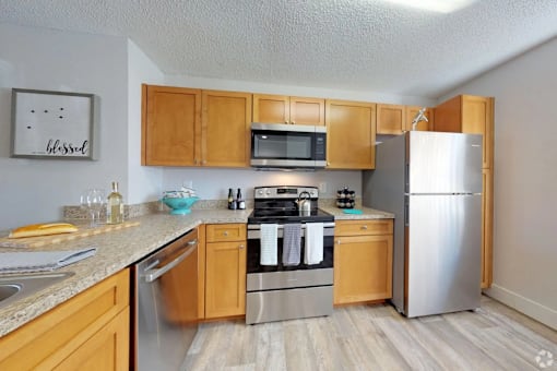 A kitchen with wooden cabinets and stainless steel appliances.