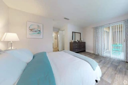 A bedroom with a large bed and a painting on the wall.